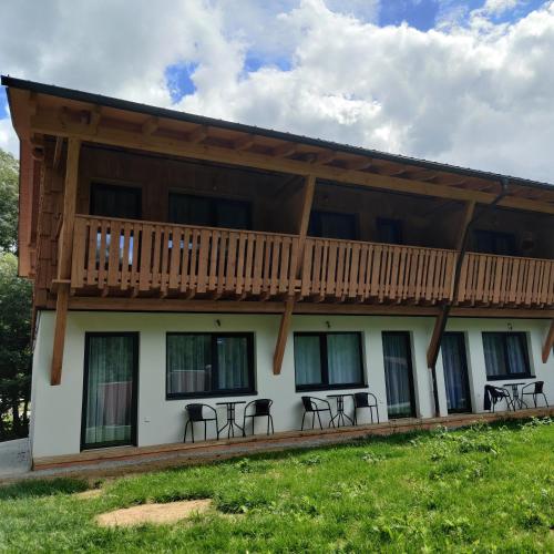a building with a balcony with tables and chairs at Gallien - Hopfenboden in Pernegg