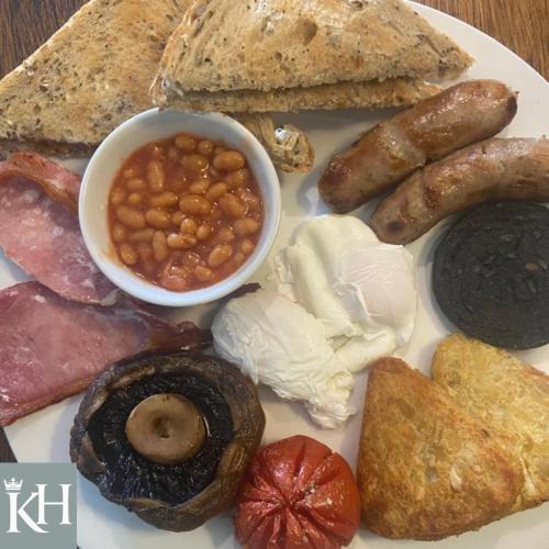 a plate of food with sausage beans and bread at Kings Head - Riverside, Ravenstonedale in Ravenstonedale