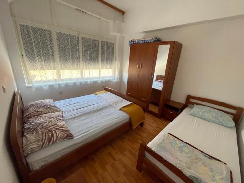 a small bedroom with two beds and a mirror at Eva Apartment 2 in Trogir