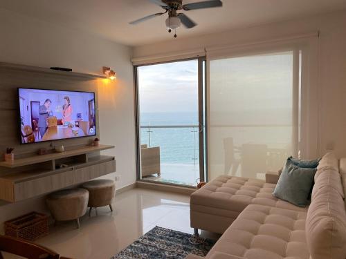 a living room with a couch and a large window at Paraíso frente al Mar Caribe en Cartagena. in Cartagena de Indias