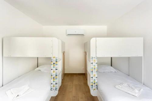 two bunk beds in a room with white walls at La Grignotière Lodge & Spa in Crecy la Chapelle