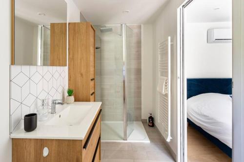 a bathroom with a sink and a shower and a bed at La Grignotière Lodge & Spa in Crecy la Chapelle