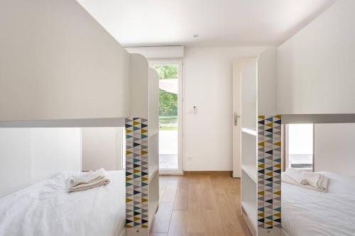a bedroom with two beds and a large window at La Grignotière Lodge & Spa in Crecy la Chapelle