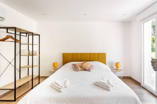 a bedroom with a large white bed with two tables at La Grignotière Lodge & Spa in Crecy la Chapelle