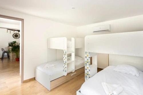 a white bedroom with a bed and a lamp at La Grignotière Lodge & Spa in Crecy la Chapelle
