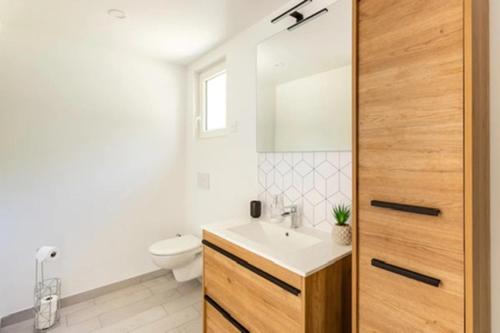 a bathroom with a white toilet and a sink at La Grignotière Lodge & Spa in Crecy la Chapelle