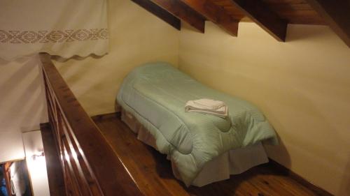 a small bedroom with a green bed in a room at KaiKen Lauquen in Trevelin