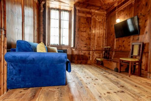 a blue couch in a room with wooden walls at Curt di Clement Eco Mobility Hotel in Tirano