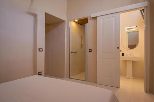 Un dormitorio con una cama y un baño con lavabo. en le CASINE di MARUGGIO 4, en Maruggio