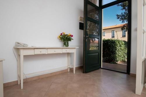 a room with a door and a table with flowers on it at Salvapiano Holiday Ranch in Riotorto