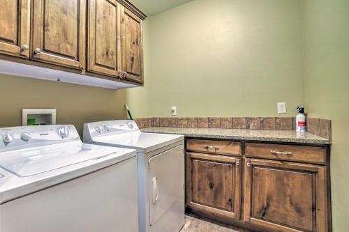 a kitchen with a washer and dryer and wooden cabinets at Cozy Driggs Condo about 40 Mi to Grand Teton NP! in Driggs