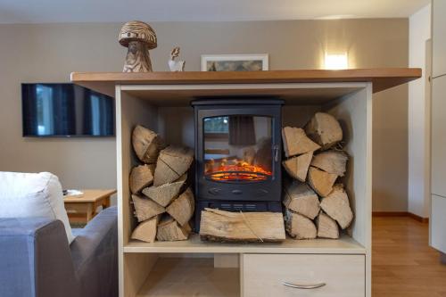 a wood stove in a book shelf with logs at Chalet Alpina in Ortisei