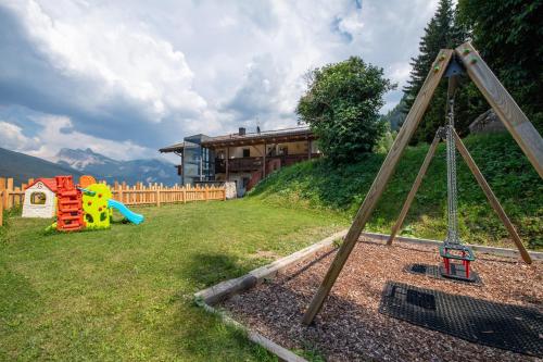 a playground with a swing set in a yard at Chalet Alpina in Ortisei