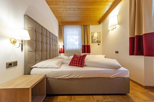 a bedroom with two beds and a wooden ceiling at Chalet Alpina in Ortisei