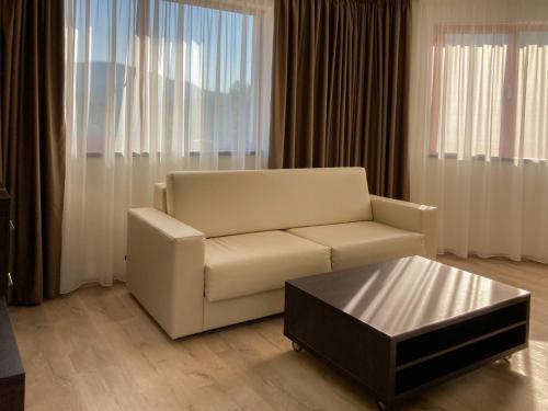 a living room with a white couch and a coffee table at Hotel Slunný Dvůr in Jeseník