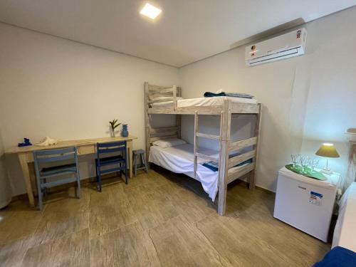 a small room with a bunk bed and a desk at Santa Hospedaria Beach in Bertioga
