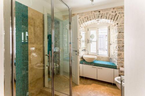a bathroom with a glass shower and a sink at Luxury 6 bedroom house on waterfront in Perast
