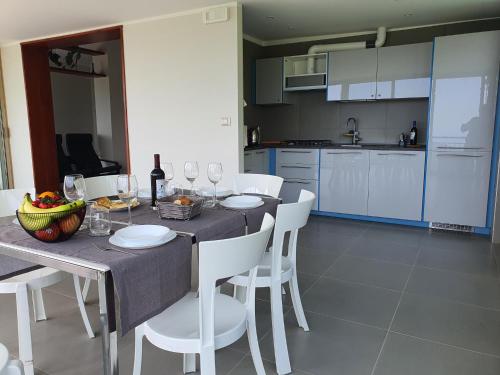eine Küche mit einem Tisch und Stühlen mit Weingläsern in der Unterkunft La Terrazza sul Golfo in Rapallo
