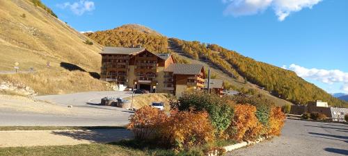 un bâtiment sur le côté d'une montagne dans l'établissement La Foux 2 pièces, à Allos