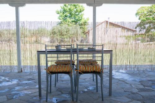 a table with cushioned chairs on a patio at Casa Vista Al Mar in Dhíkella