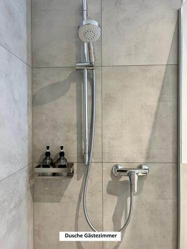 a shower with a shower head in a bathroom at "Auslese 54" -Direkt am Moselufer- Gästezimmer & Ferienwohnung in Traben-Trarbach