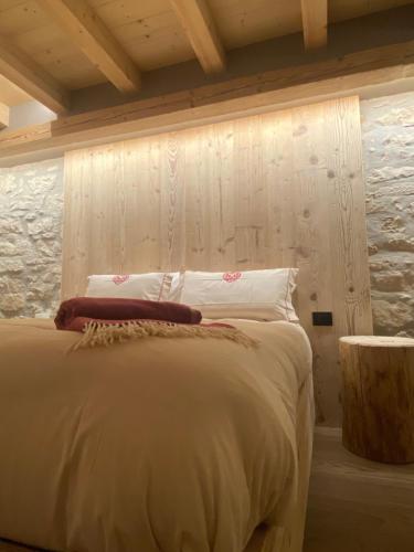 a bedroom with a bed with a wooden wall at Il Falco Affittacamere in Gallio