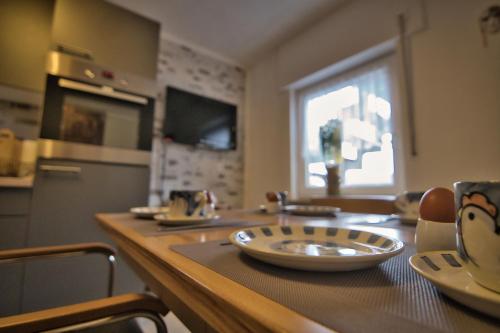 a kitchen with a wooden table with plates on it at Im Vulkanland Fewo bis 6 Personen in Ettringen