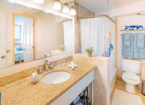 een badkamer met een wastafel, een toilet en een spiegel bij Vacation Apartments in Honolulu Hawaii in Honolulu