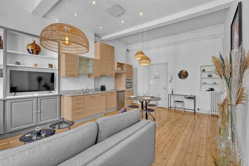 Il comprend un salon avec un canapé gris et une cuisine. dans l'établissement Le Salini, à Toulouse