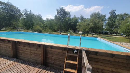 a swimming pool with a ladder on a wooden deck at Natur'O Médoc in Naujac-sur-Mer