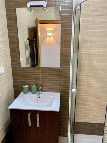 a bathroom with a sink and a shower and a mirror at Sea to Sky Suites - Mijas Pueblo in Mijas