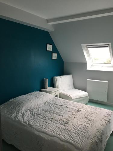 1 dormitorio con cama y pared azul en A 50m de la mer en Agon Coutainville