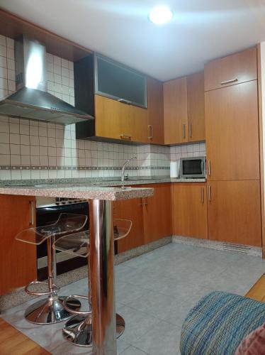a kitchen with wooden cabinets and a marble counter top at estudio centro vigo in Vigo