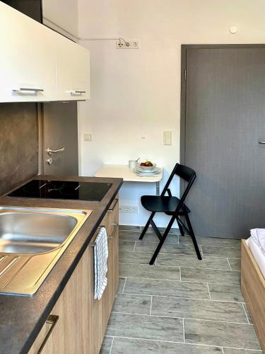 a kitchen with a black chair and a sink at Dock 6 - Cuxhaven in Cuxhaven