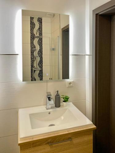 a bathroom with a white sink and a mirror at Dock 6 - Cuxhaven in Cuxhaven