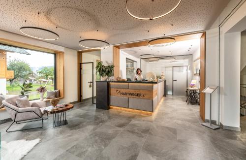 a lobby of a pharmacy with a woman standing at a counter at Hartweger's Hotel in Haus im Ennstal