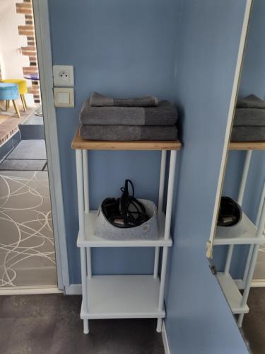 a room with two shelves with towels and a mirror at Le Gite de la Loire in Rochecorbon