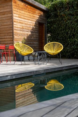 three yellow tables and chairs next to a swimming pool at Artemisia Boutique Hotel in Bastelica
