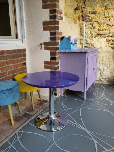 a purple table and two chairs and a desk at Le Gite de la Loire in Rochecorbon