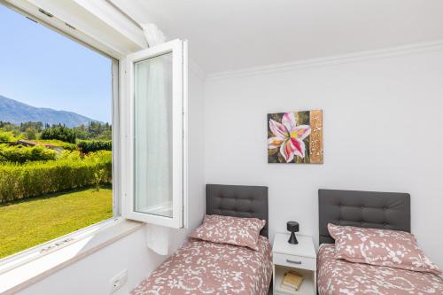 a bedroom with a bed and a window at Green paradise with swimming pool in Gruda