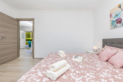 a bedroom with a bed with towels on it at Green paradise with swimming pool in Gruda
