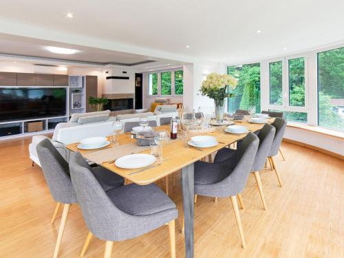 uma sala de jantar com uma grande mesa de madeira e cadeiras em VILLA AVEC PISCINE PRIVEE em Auberville