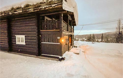 a log cabin in the snow with a light at Nice Home In Vinstra With Kitchen in Vinstra