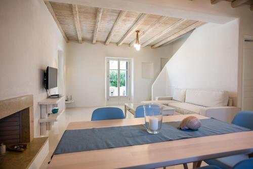 a living room with a table and blue chairs at Anemos Sails 4 in Pounda