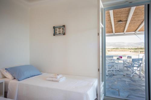 a bedroom with a bed and a patio with a table at Anemos Sails 4 in Pounda