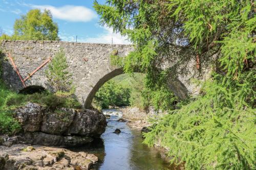 an old stone bridge over a river with a creek at Larch in Newtonmore