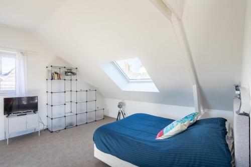 - une chambre avec un lit bleu et une télévision dans l'établissement TERANGA - Studio proche CHU avec grande terrasse, à Rennes