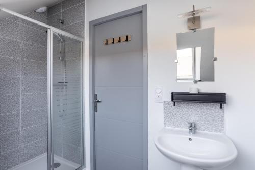 une salle de bain blanche avec un lavabo et une douche dans l'établissement Teranga - Studio avec grande terrasse dans Rennes, à Rennes