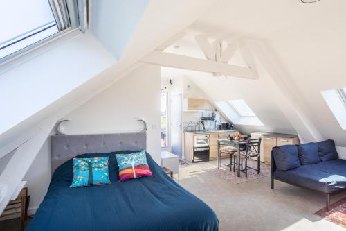 - une chambre mansardée avec un lit bleu dans l'établissement Teranga - Studio avec grande terrasse dans Rennes, à Rennes