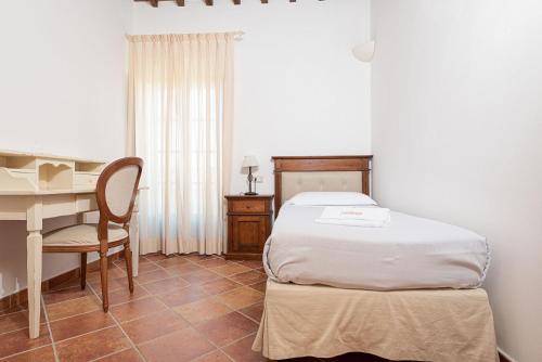 a bedroom with a bed and a desk and a table at Salvapiano Holiday Ranch in Riotorto
